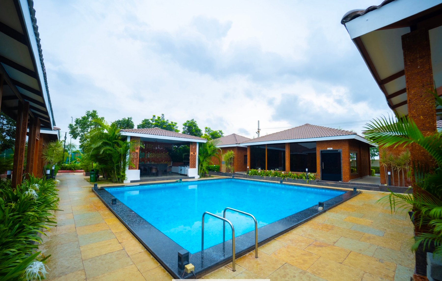 Pool lawn area with resort buildings and greenery